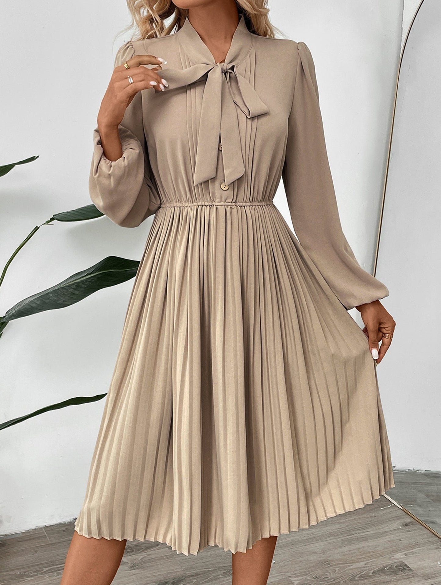 Elegant pleated dress with bow tie collar