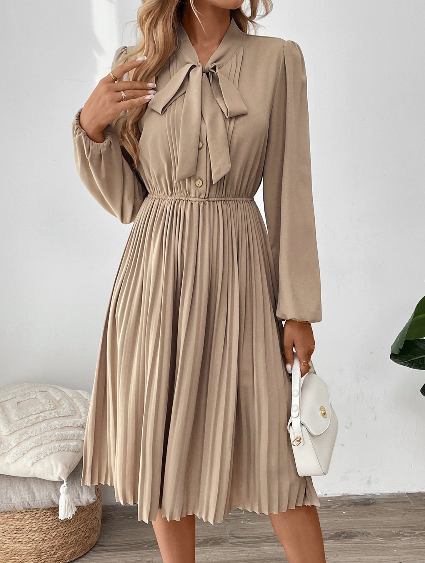 Elegant pleated dress with bow tie collar