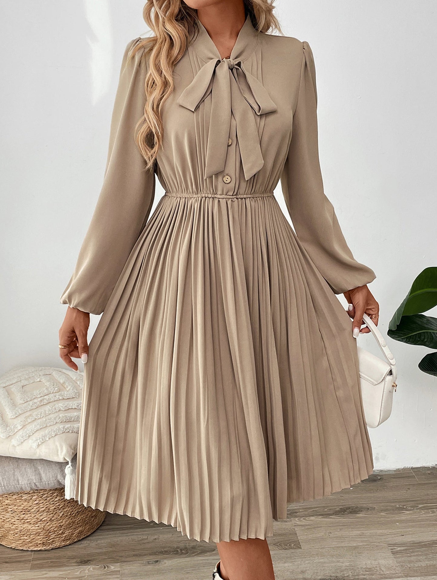 Elegant pleated dress with bow tie collar