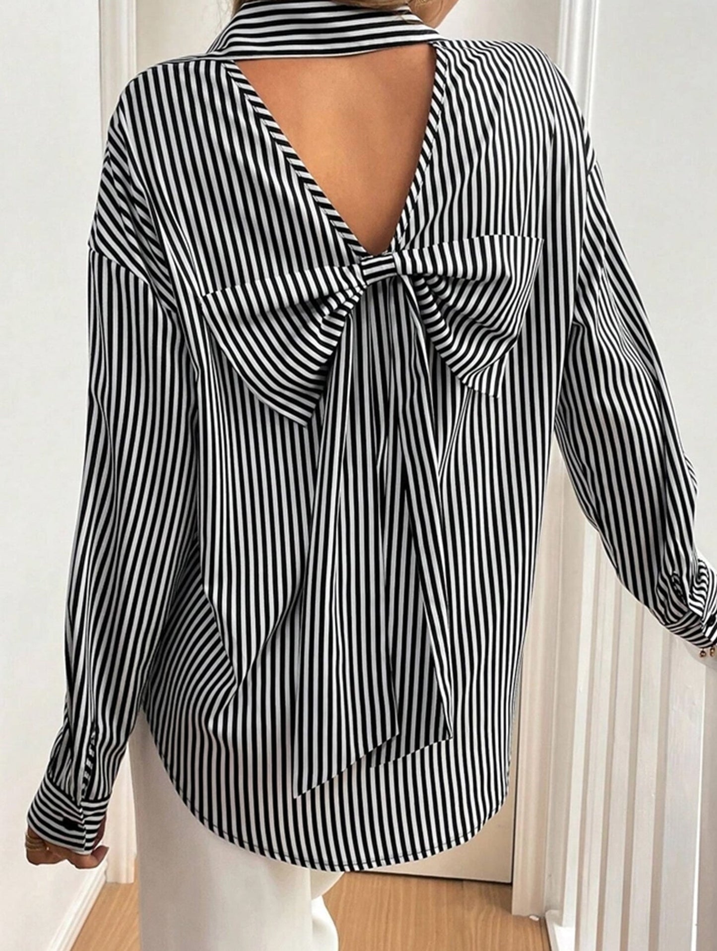 A striped printed long-sleeved shirt with a bow