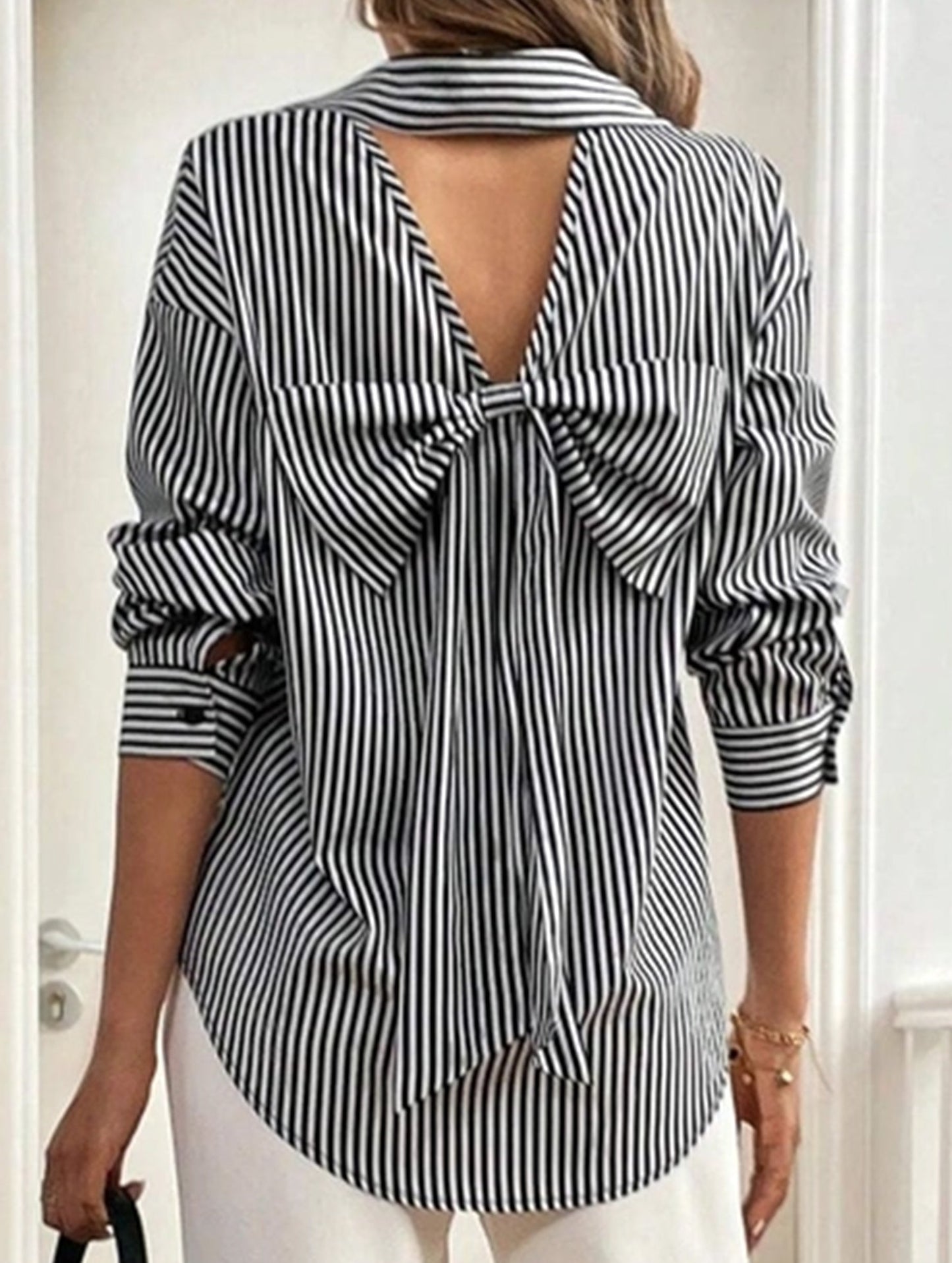 A striped printed long-sleeved shirt with a bow