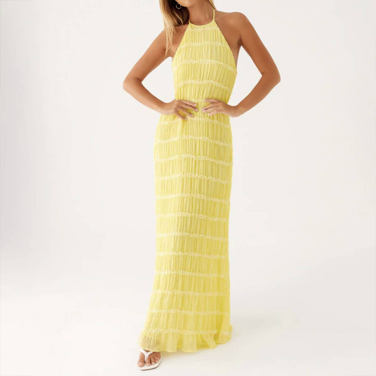 A long dress with a halter strap and pleated lace